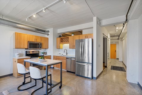 a kitchen with stainless steel appliances and a table with chairs