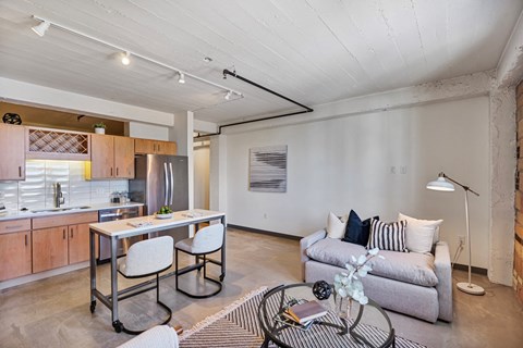 a living room with a couch and a kitchen with a table and chairs