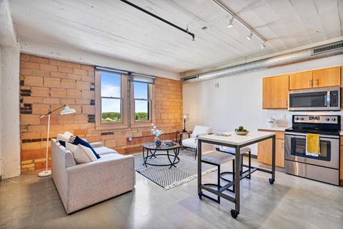 a living room with a couch and a kitchen with a table