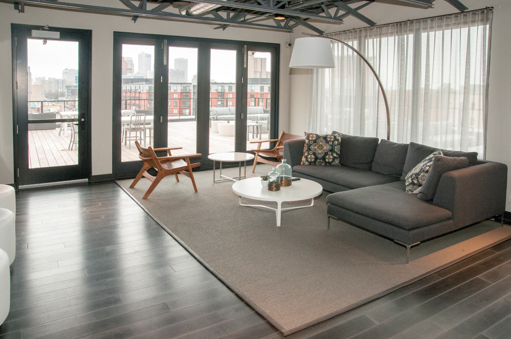Community Room with Large Grey Sectional And Floor to Ceiling Windows at 700 Central Apartments, Minneapolis, 55414