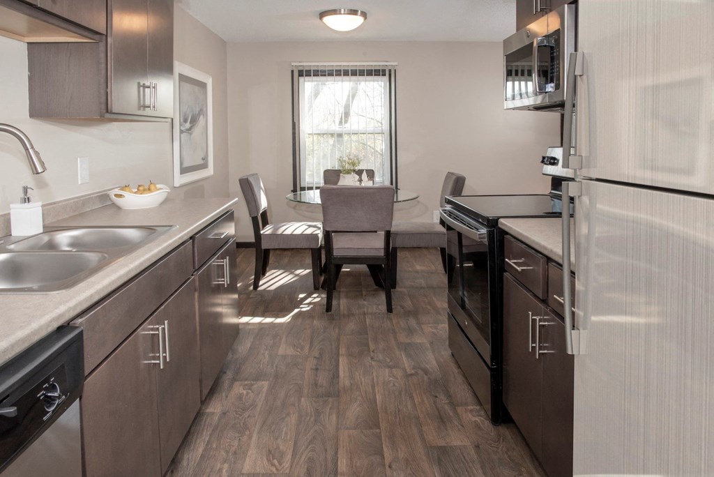 one plus den model, dining and kitchen with new slate cabinetry, stainless steel appliances