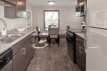 one plus den model, dining and kitchen with new slate cabinetry, stainless steel appliances - Photo Gallery 6