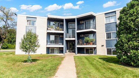 A large apartment complex with a walkway in front.