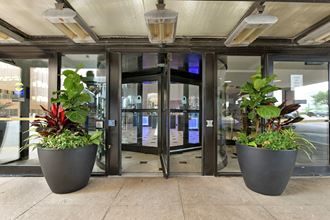 an entrance to a building with two large planters in front of the door