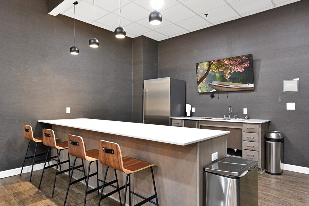 a kitchen with a long counter and chairs