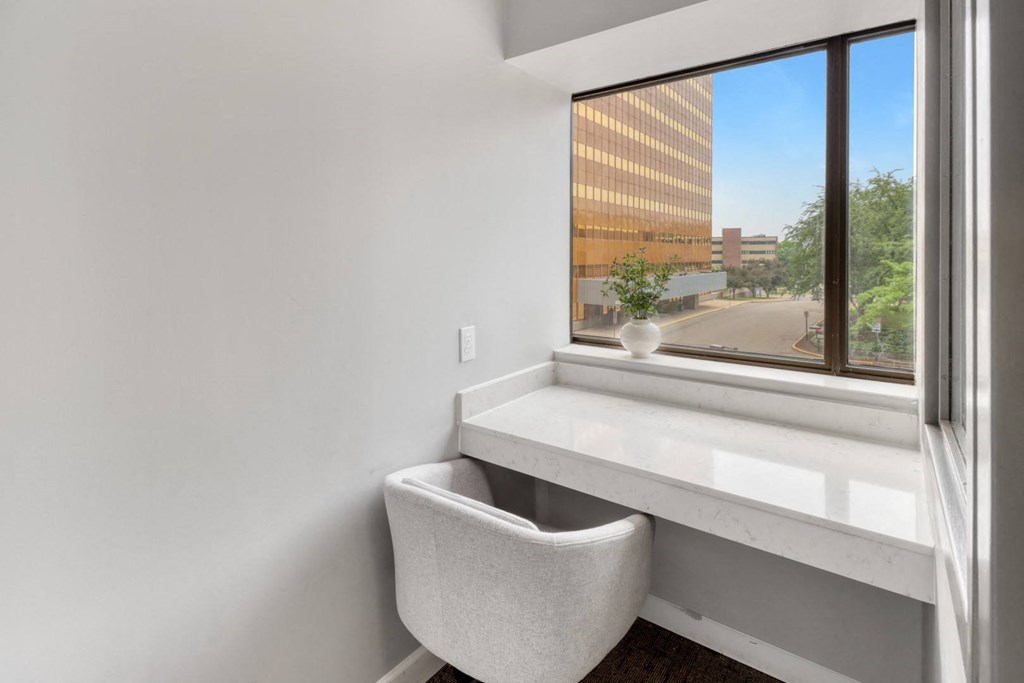 a room with a large window and a white chair