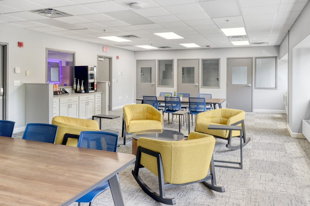 a common area with tables and chairs and a television