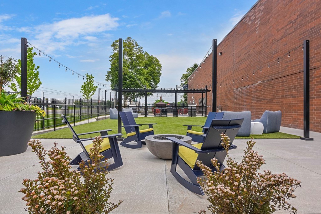 a patio with chairs and a fire pit