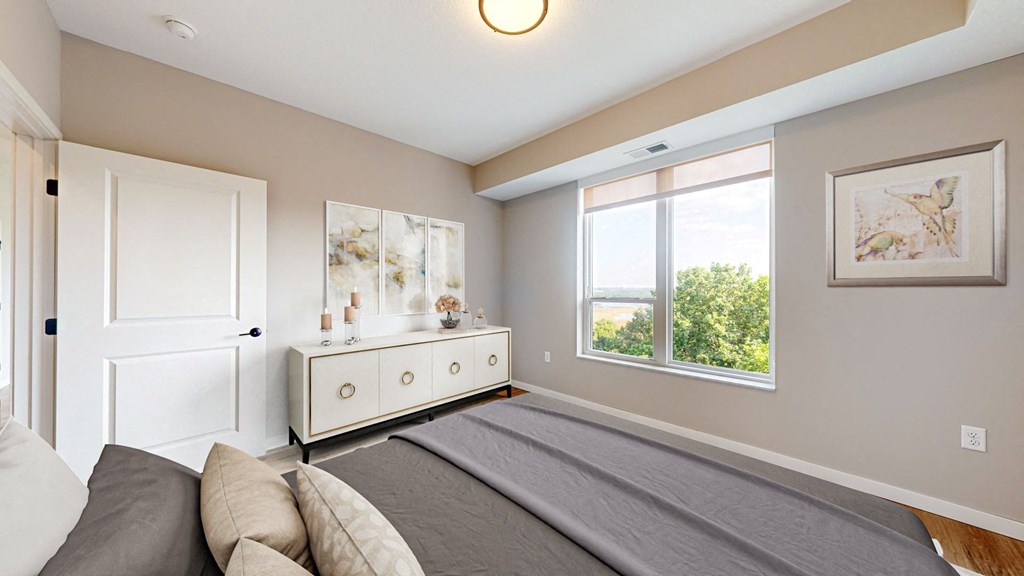 a bedroom with a large bed and a window at Ardor on the Bluffs South Loop Residences Apartments, Bloomington, Minnesota