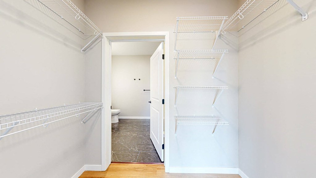 a walk in closet with two white closets and a toilet at Ardor on the Bluffs South Loop Residences Apartments, Minnesota, 55425