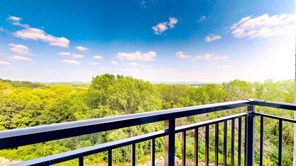 a balcony with a view of trees and a blue sky at Ardor on the Bluffs South Loop Residences Apartments, Bloomington, MN, 55425