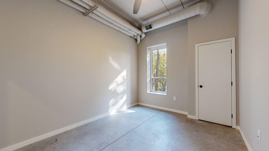 an empty room with a door and a window at Ardor on the Bluffs South Loop Residences Apartments, Bloomington