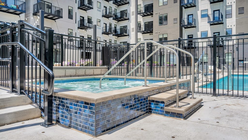 A small pool with a metal railing and steps leading to it.