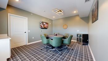 a meeting room with a table and chairs and a flat screen tv on the wall
