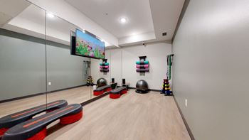 a workout room with weights and a flat screen tv