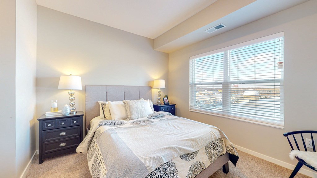 a bedroom with a large window and a large bed