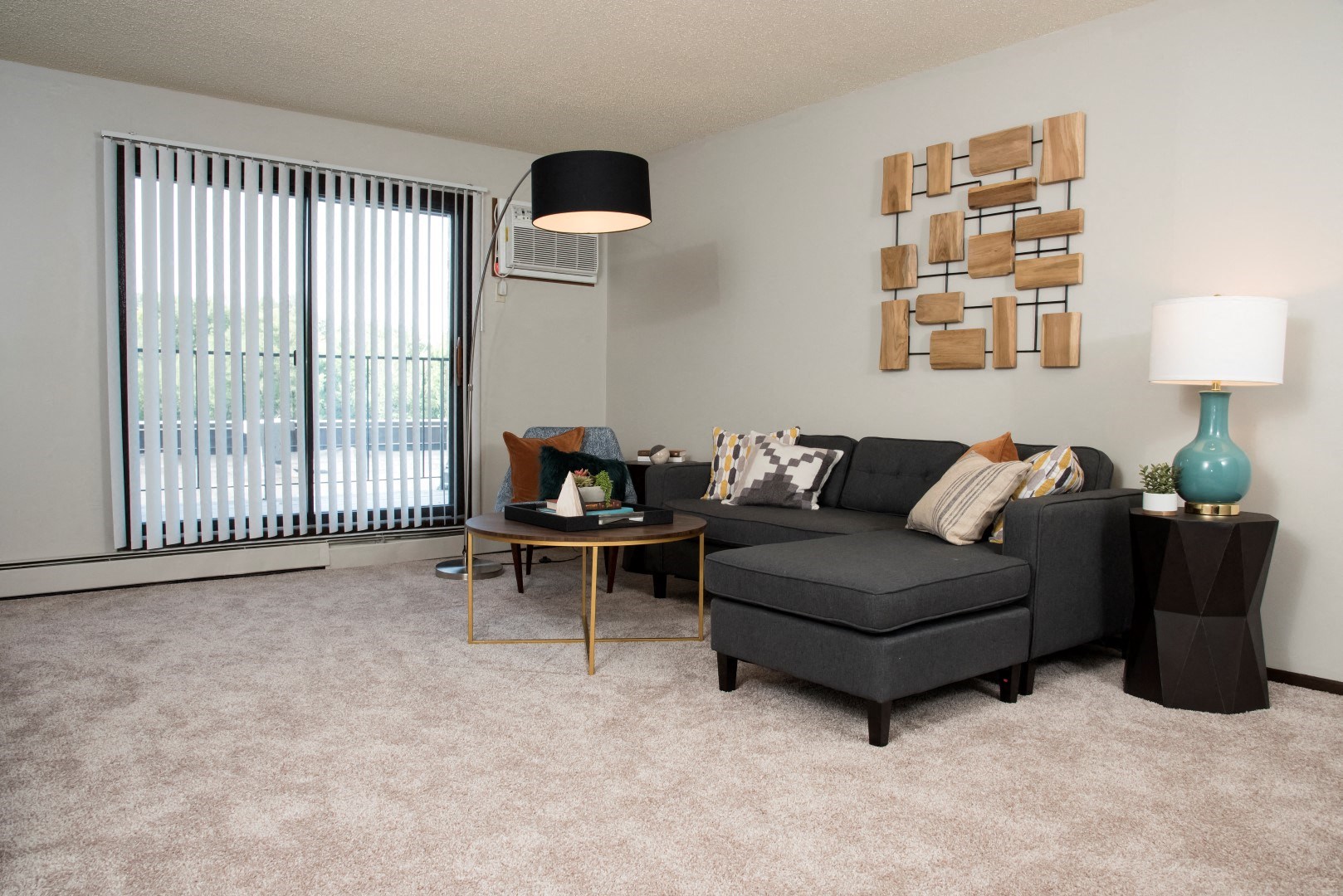 a living room with a black couch and a large window