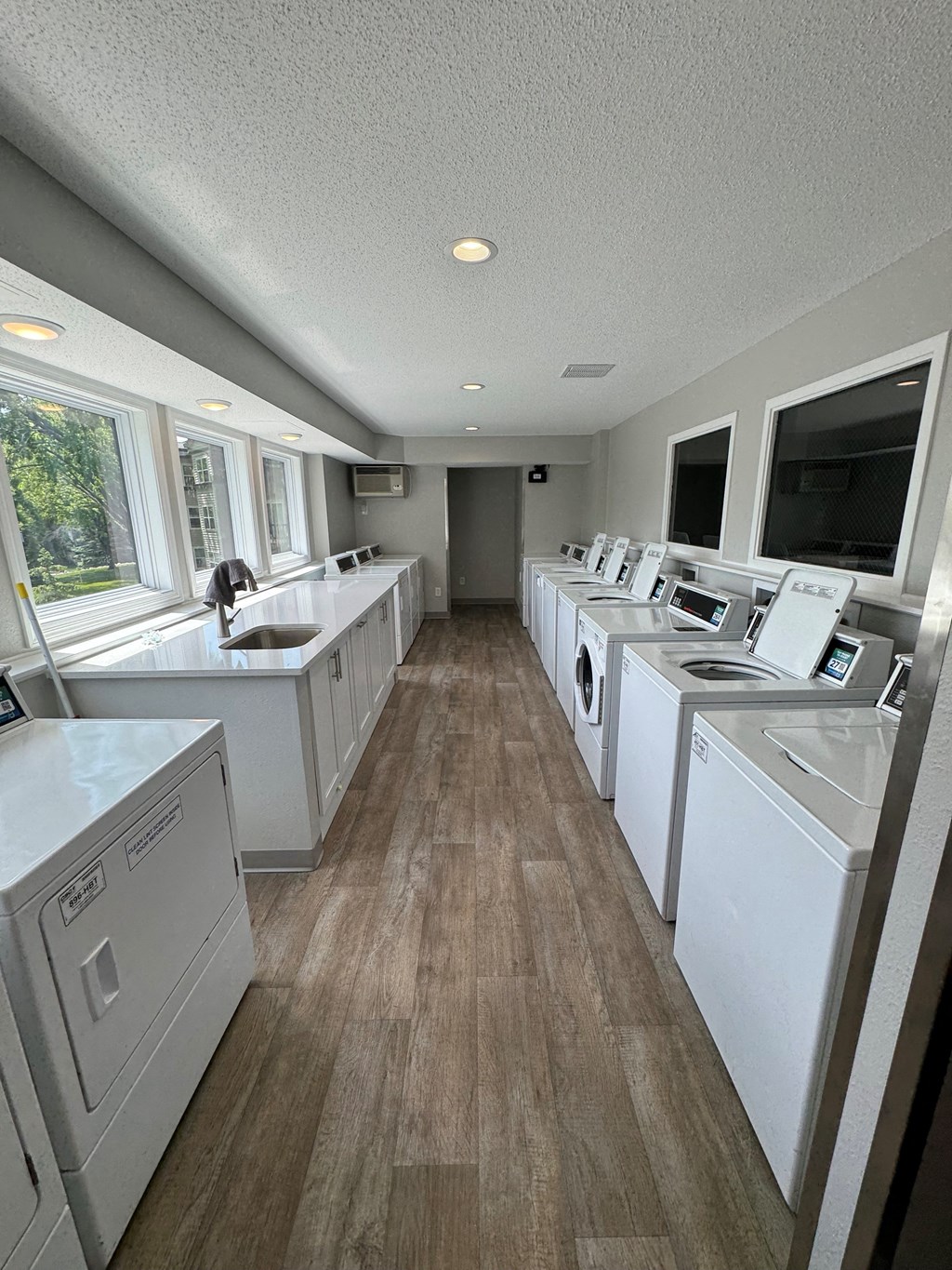 a laundry room with washes and dryers and a tv