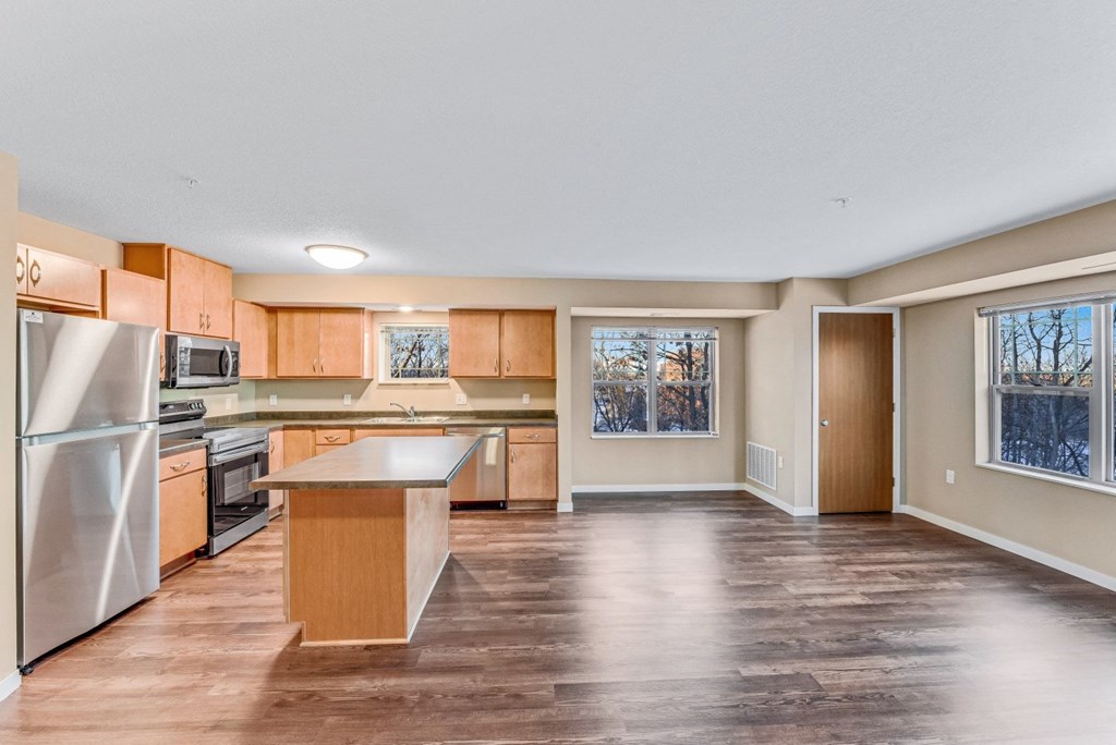 the spacious kitchen with stainless steel appliances and wooden cabinets