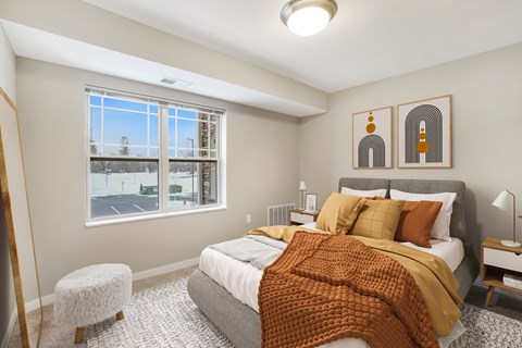 A bedroom with a large bed and a window overlooking a parking lot.