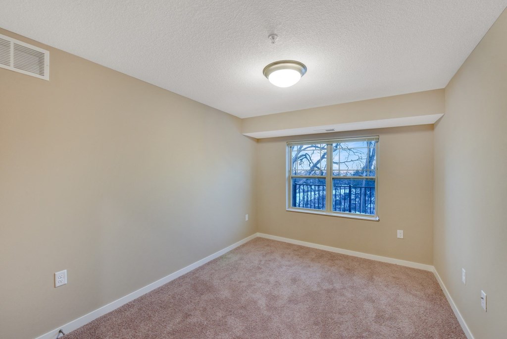 an empty room with carpet and a window
