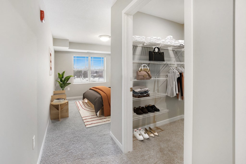 a walk in closet with a bed and shoes in it