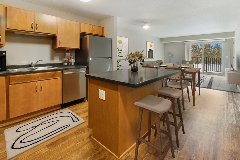 a kitchen with a large island with bar stools and a dining table
