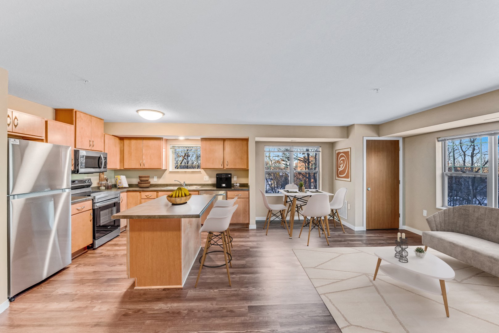 a living room with a kitchen and a table with chairs