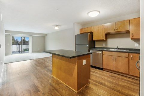 A kitchen with wooden cabinets and a black countertop.