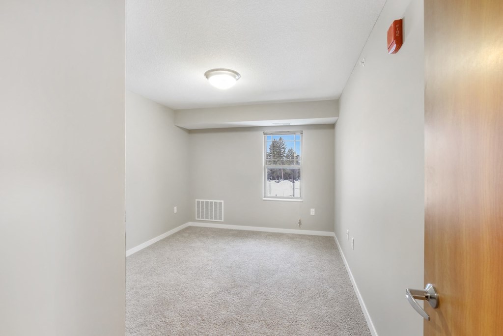 an empty room with a window and a door