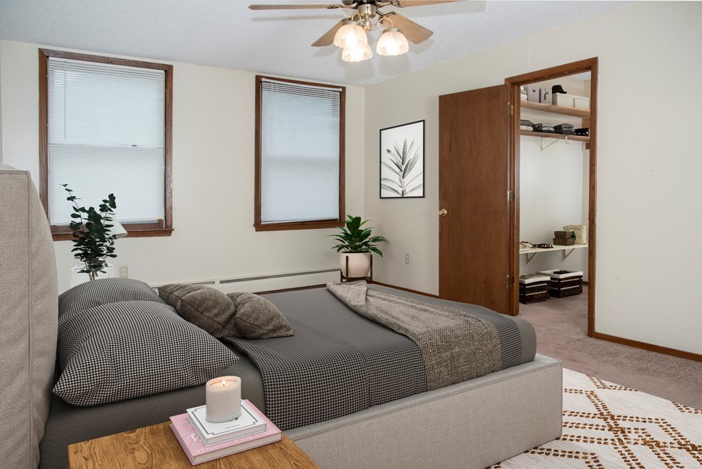 a bedroom with a bed and a ceiling fan