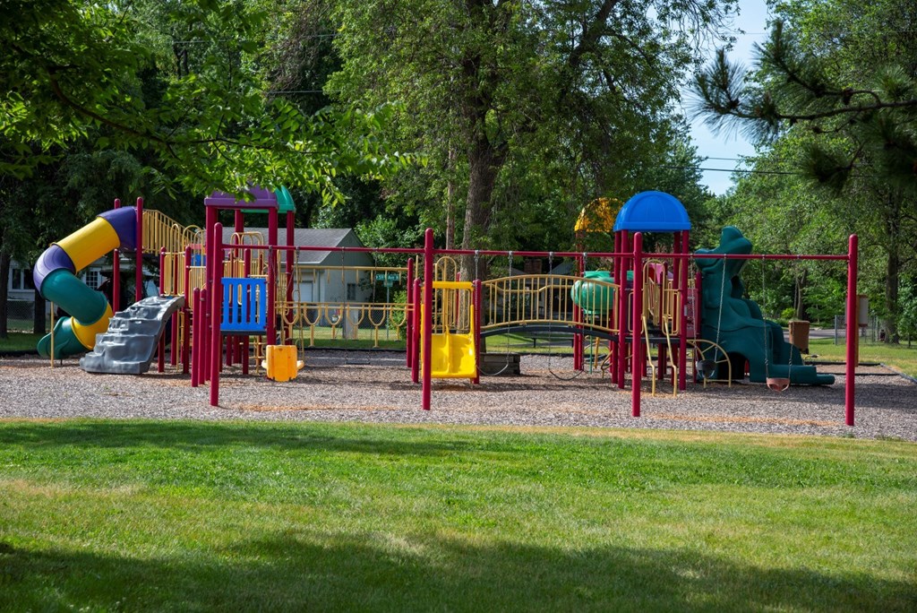 a playground with several slides and other toys in a park