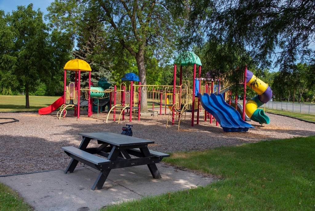 a playground with a picnic table in front of it