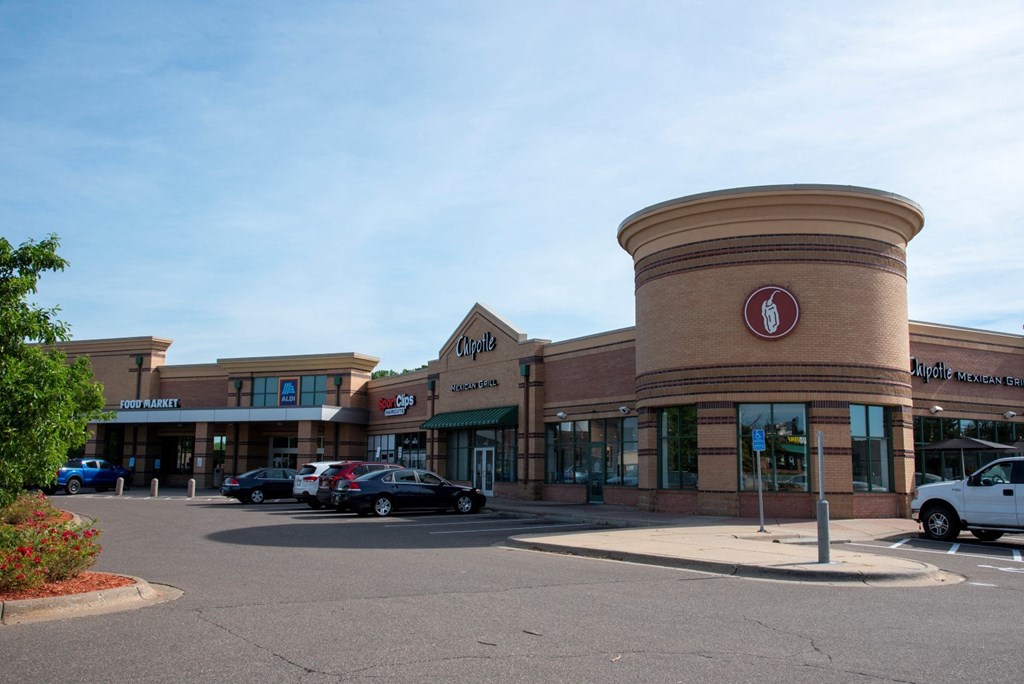the front of a shopping mall with cars parked outside