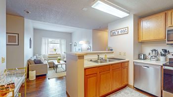 the view of a kitchen and living room with a couch