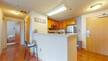 a kitchen with a bar and a door to a bedroom