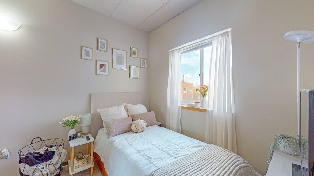 a small bedroom with a bed and a window