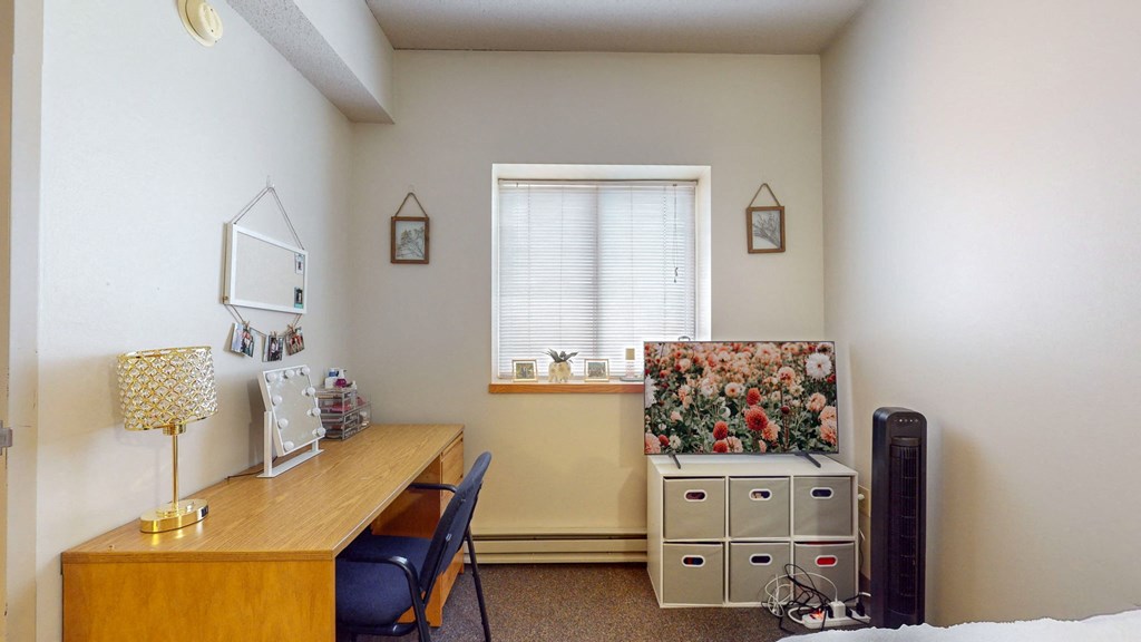 a home office with a desk and a television