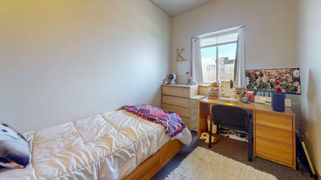 a bedroom with a bed and a desk