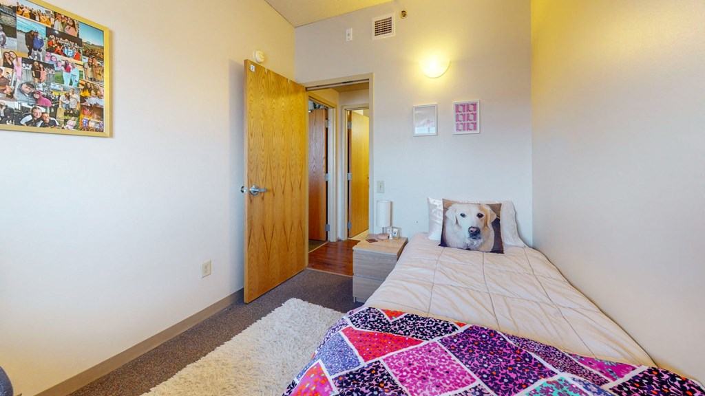 a bedroom with a bed and a door to a bathroom