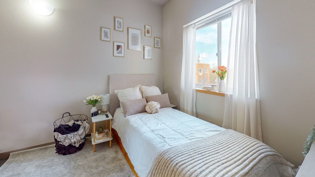 a small bedroom with a bed and a window