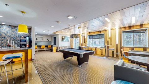 a game room with a pool table and a bar