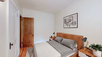 a bedroom with a medium sized bed and a door that leads to a bathroom