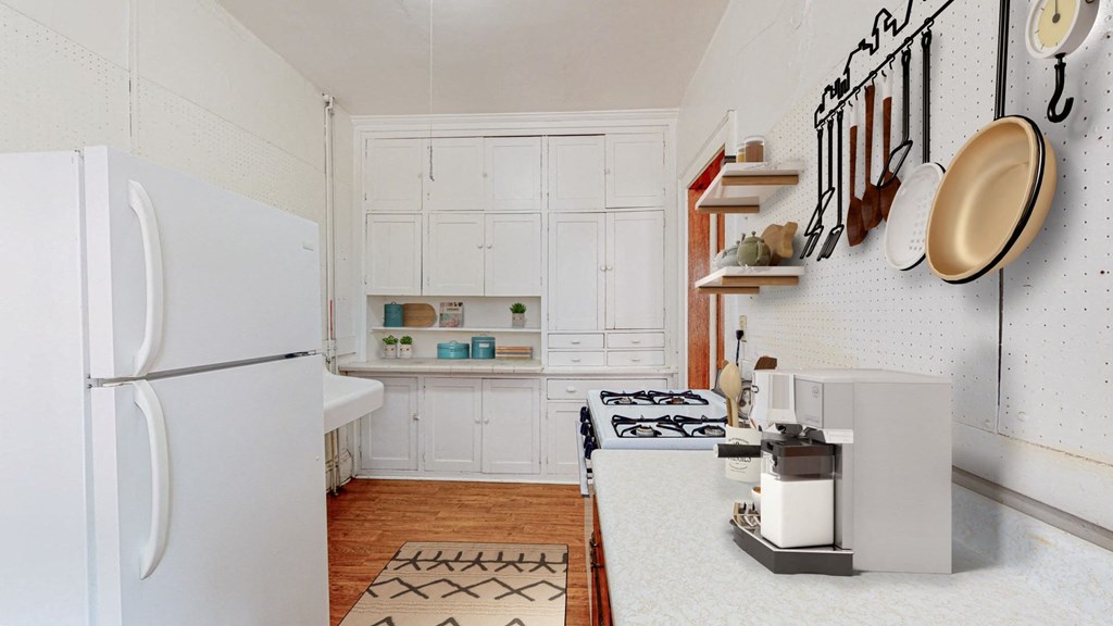 a kitchen with white cabinets and a white refrigerator