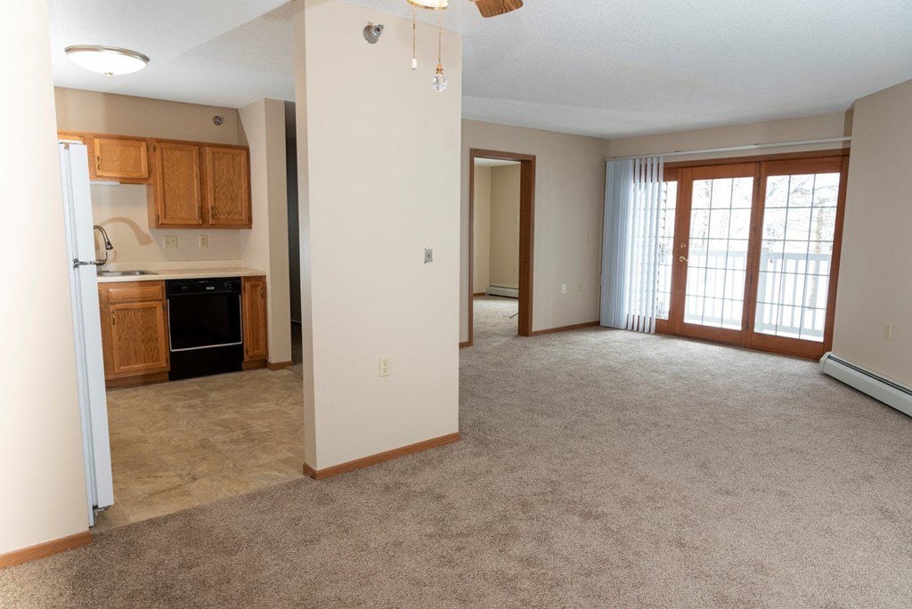 an open living room with a kitchen in the background  at Briarcliff Apartments, a 55+ Community, Minnesota