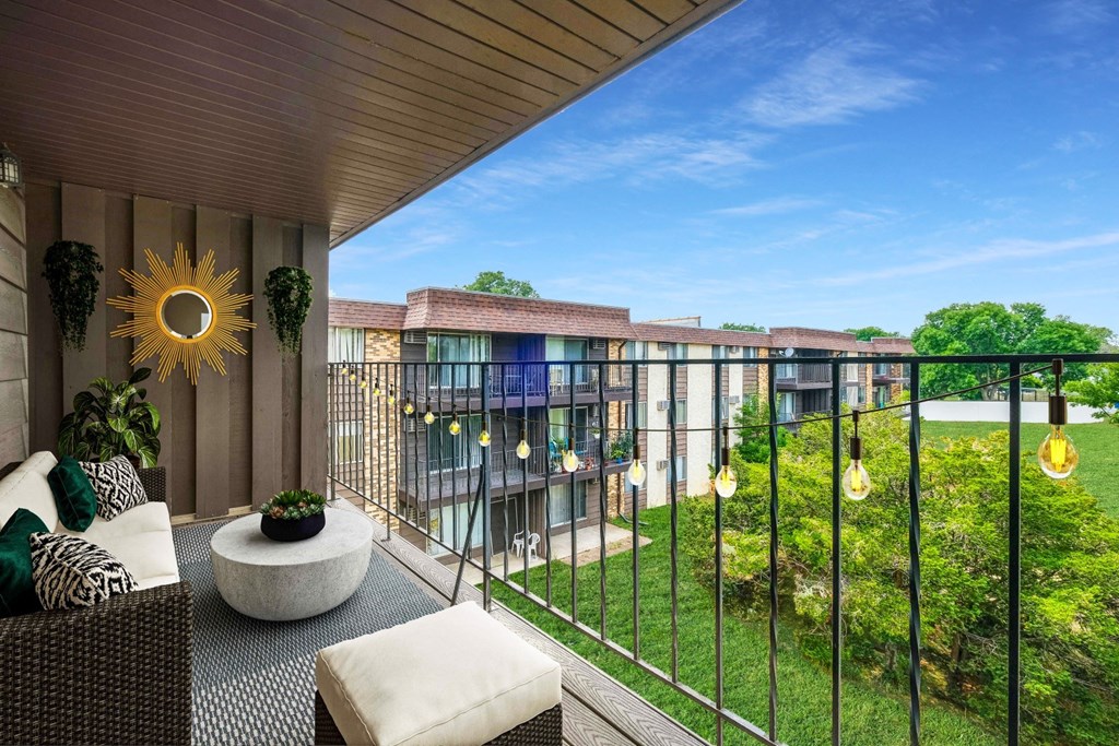 a balcony with a view of a garden and a building