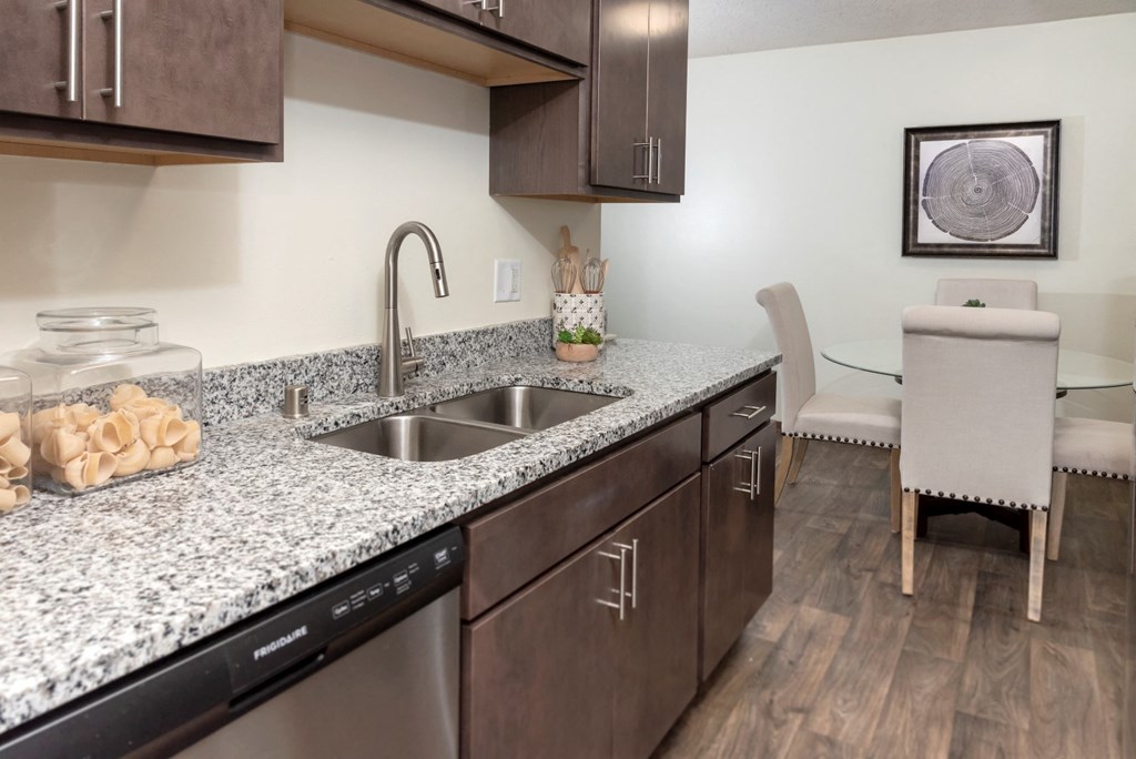 a kitchen with granite countertops and a stainless steel sink