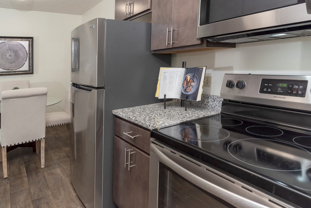 a kitchen with stainless steel appliances and a granite counter top and a stainless steel refrigerator