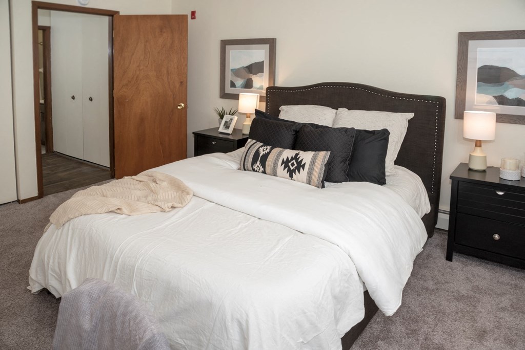 a bedroom with a large bed with white comforter and pillows