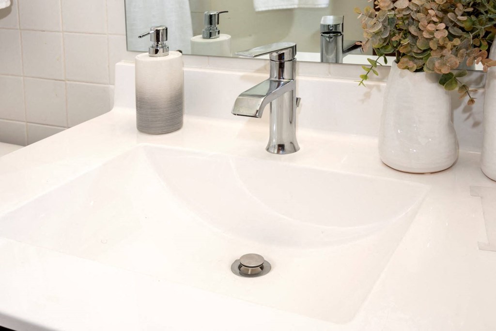 a white sink with a silver faucet in a bathroom
